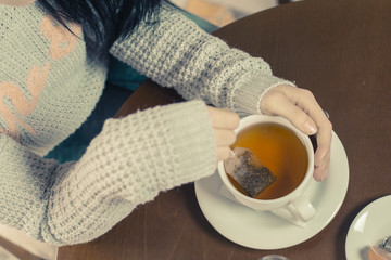 Young brunette Caucasian woman is drinking tea at a bar.
