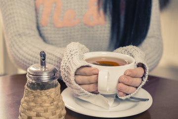 Young brunette Caucasian woman is drinking tea at a bar.