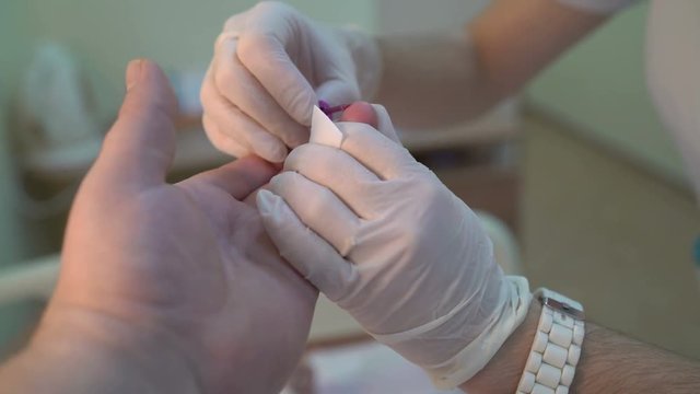 Patient receives a finger prick blood test during an examination at hospital