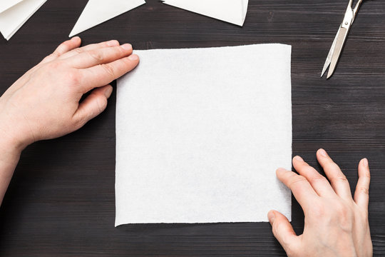 hands hold blank piece of paper on table