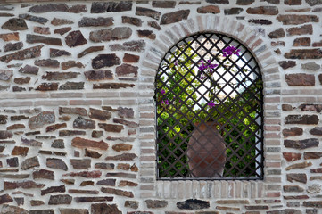 stone wall and window with flower pot
