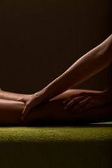 close-up masseur hands doing spin massage. low key photo