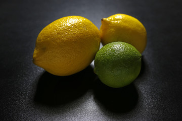 lemons and lime fruits on black background