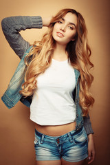 Young beautiful curly woman posing  over yellow background