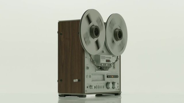 Old reel tape recorder with spinning reels on white background. Reel to reel tape playing on a tape machine, Slow motion.