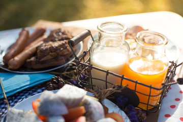Various breakfast table with fruits egg and sausage, orange juice and milk