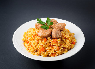 rice with meat and vegetables on a white plate. Pilaf isolated 