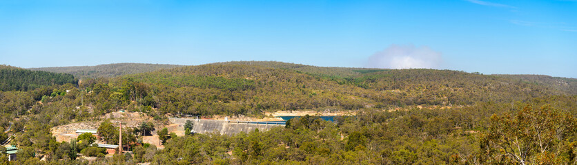 Fototapeta na wymiar Mundaring Weir - Stausee für die Trinwasser Versorgung der Region Perth, Westaustralien, Australien. Rauchwolke am Horizont von einem Buschbrand.