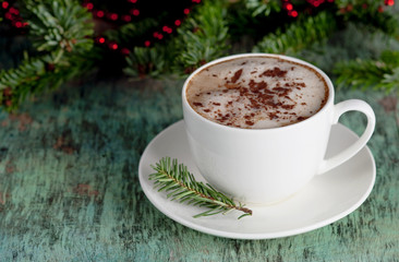 Obraz na płótnie Canvas A cup of coffee on a wooden background. Coffee cappuccino with Christmas decorations and fir branches on the old wooden background. Cocoa Cappuccino Coffee Cup of coffee Wooden background