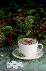 A cup of coffee on a wooden background. Coffee cappuccino with Christmas decorations and fir branches on the old wooden background. Cocoa Cappuccino Coffee Cup of coffee Wooden background