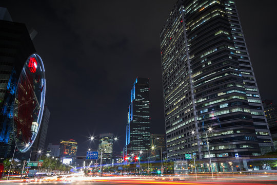 View of light trails and modern skyscrapers in the Gangnam District in Seoul, South Korea at night.