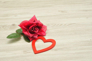 Valentines day. A red heart with an artificial red rose
