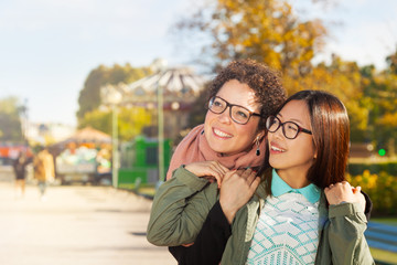 Fototapeta premium Happy girls friends hugging walking at autumn park