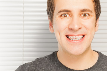 Happy young man with orthodontic cases