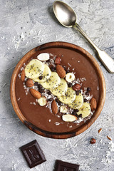 Chocolate banana smoothie bowl with nuts and chia seeds.Top view