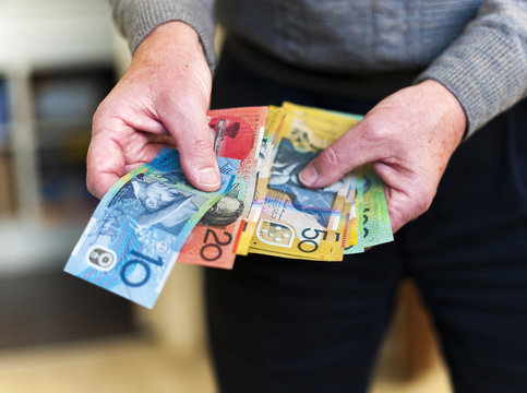 Handing over individual Australian banknotes.
