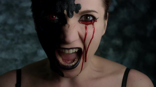 4k Shot of a Woman with Halloween Make-up With Blood tears, screaming