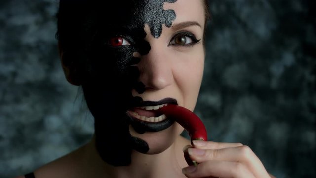4k Shot of a Woman with Halloween Make-up Eating Hot Chilli Pepper