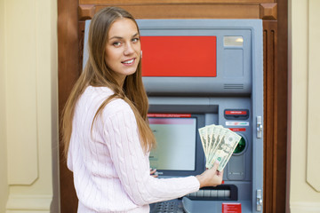 Young blonde woman is holding a cash dollars