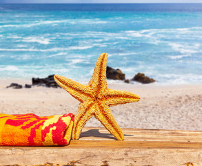 Fototapeta na wymiar étoile de mer et serviette sur plage de la Réunion 