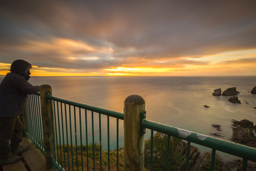 Man Enjoying Sunrise View At Nugget Point Lookout Platform at Ca
