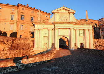 Obraz premium Bergamo - Old city (Citta Alta). One of the beautiful city in Italy. Lombardia. Landscape on the old gate named Porta San Giacomo during the sunrise and a wonderful blu day