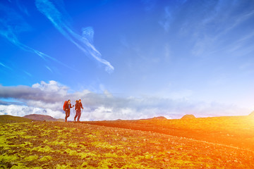 hikers on the trail in the Islandic mountains. Trek in National Park Landmannalaugar, Iceland. valley is covered with bright green moss © vitaliymateha