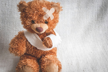 concept teddy bear childhood diseases at textile background