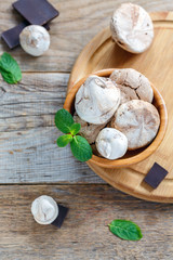 Old wooden table with chocolate meringue.