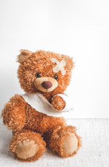 concept teddy bear childhood diseases at textile background
