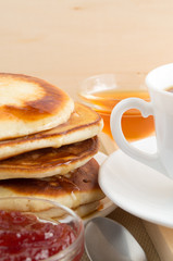 Pancake with honey and jam and white cup of tea