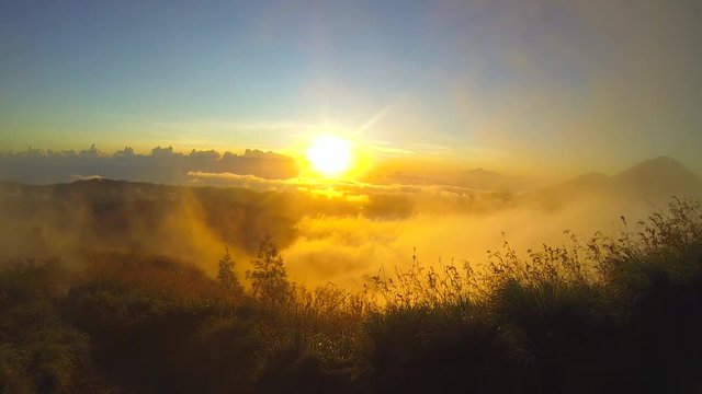 Golden Sunrise thru clouds over Lake Batur with view from peak of Batur volcano. GoPro HD. Bali, Indonesia.