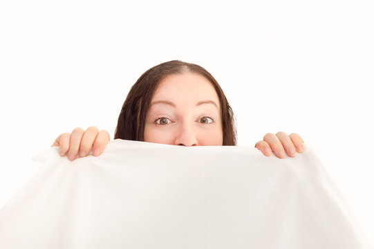 woman surprised hiding under the sheets