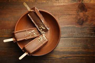 Classic chocolate ice cream with nuts in a clay plate. Close-up.