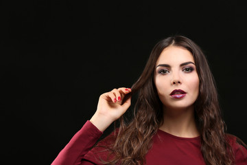 Portrait of beautiful young woman model with bright makeup on dark background