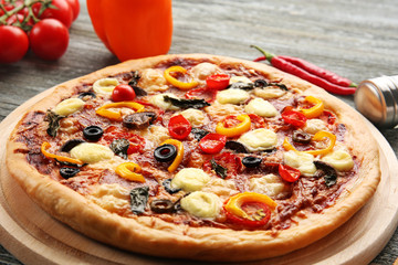 Freshly baked  pizza with ingredients on wooden table