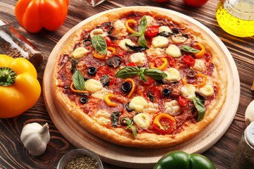 Freshly baked  pizza with ingredients on wooden table