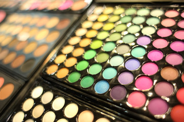 Assortment of different colourful eye shadow palettes in cosmetic store