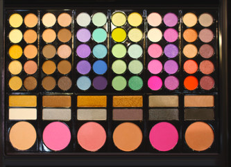 Assortment of different colourful eye shadow palettes in cosmetic store