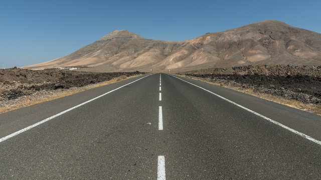 Gerade Asphalt-Straße durch Lavafelsen