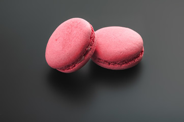 Macarons with strawberry on dark background