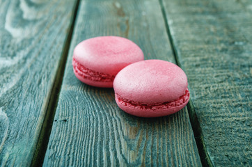 Macaroons on green wooden background