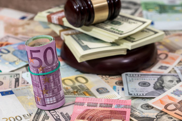 Wooden Law Gavel on Euro and Dollar background.