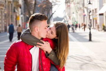young teen couple having piggyback carrying on walking street in