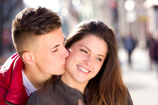 close up photo of teen couple kiss, city outdoor, walking street