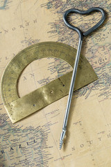 the old protractor and hand drill gimlet on vintage map, macro background, compasses, Atlantic ocean