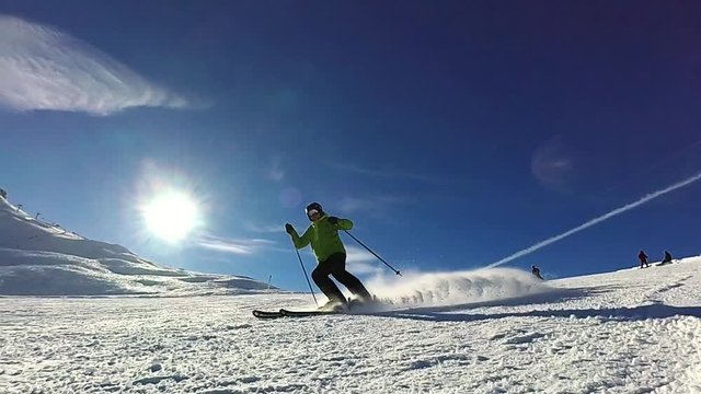 Slow motion: Skier is spraying snow into the camera on sunny day, Tignes, France
