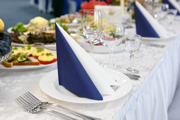 fragment of serving a festive table with blue-white napkin. Soft focus, selective focus