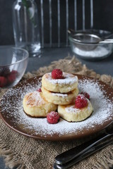Small cheese pancakes with berries and icing sugar