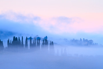 Tuscan landscape with country houses and cypresses in the fog - obrazy, fototapety, plakaty